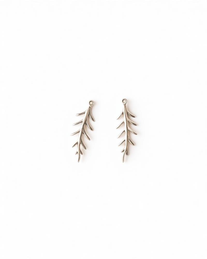 Silver earrings shaped like stylized fern fronds